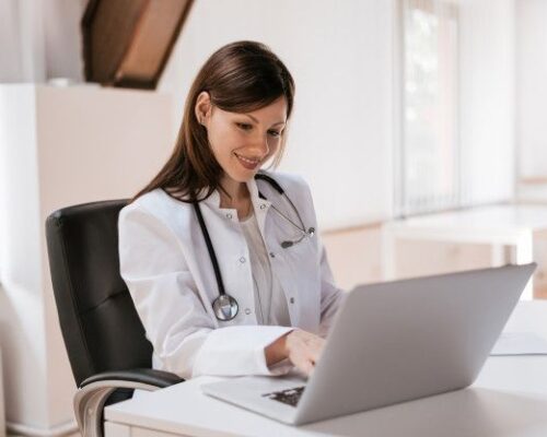 Médica no trabalho usando laptop | Foto Premium